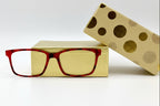 Red-framed glasses on a gold box with polka dots