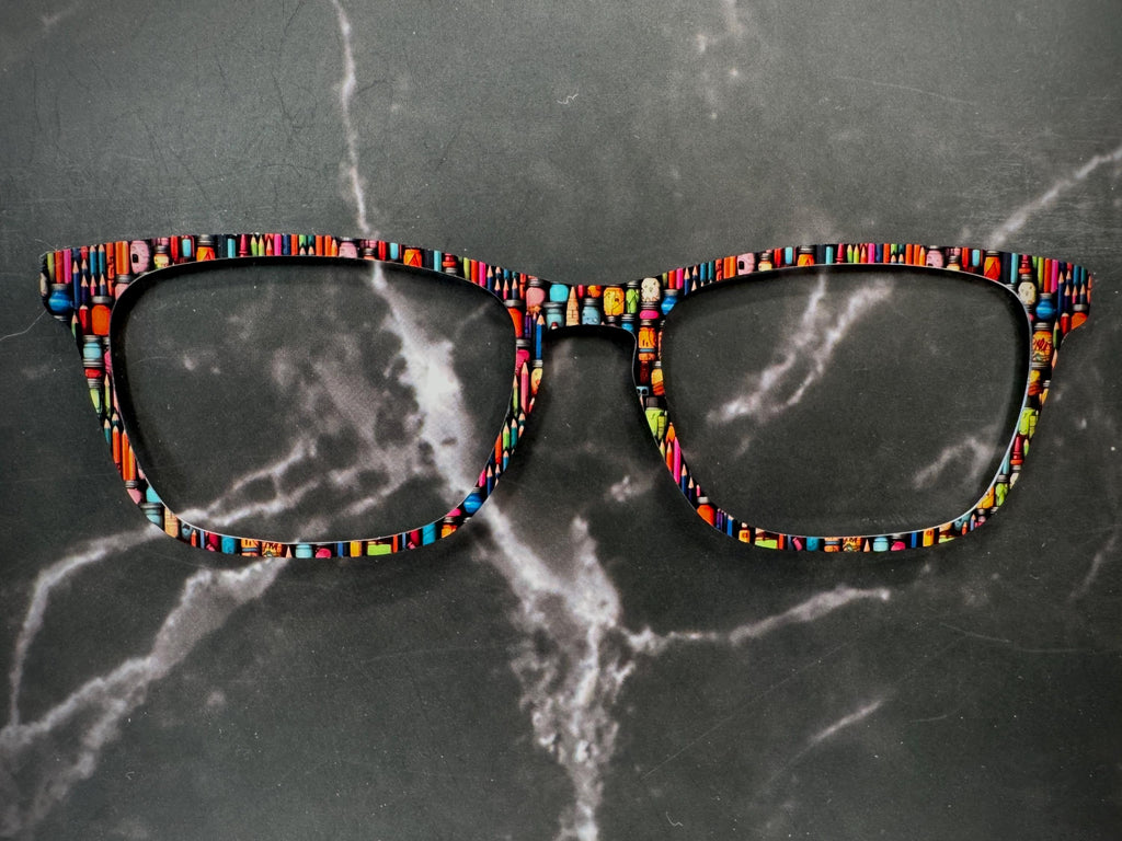 artists pencils and paints on a metal topper for pair eyewear.